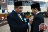 Ketua DPRD Kukar H Awang Jacoub Luthman menyematkan pin anggota DPRD Kukar usai pengambilan sumpah Junaidi sebagai anggota DPRD Kukar dari Fraksi Partai Golkar pada Rapat Paripurna Istimewa dengan acara Pergantian Antar Waktu (PAW). (Hayru Abdi/ANTARA Kaltim)