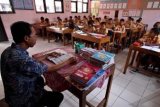 Yogyakarta (Antara Bali) - Seorang guru mengajar di Sekolah Dasar Banguntapan, Bantul, Yogyakarta, Sabtu (2/3). Badan Kepegawaian Daerah (BKD) Bantul mewacanakan penggabungan beberapa Sekolah Dasar dengan persyaratan tertentu karena saat ini Kabupaten Bantul kekurangan guru SD sebanyak 1000 orang. FOTO ANTARA/Noveradika/nym/2013.