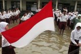 Serang (Antara Bali) - Sejumlah guru dan murid SD Negeri Lopangdomba, Serang, Banten, Senin (4/3) menggelar upacara di halaman sekolah yang tergenang banjir. Pihak sekolah mengaku sudah berulang kali mengajukan permohonan perbaikan drainase yang rusak parah namun belum ada realisasi sehingga hampir setiap hujan turun mereka kebanjiran dan proses belajar mengajar terhambat. FOTO ANTARA/Asep Fathulrahman/nym/2013.