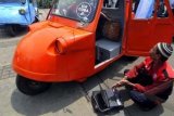 Jakarta (Antara Bali) - Seorang sopir Bemo yang tergabung dalam Paguyuban Bemo Jakarta mengecek tegangan Bemo Bio dengan netbook sebelum diuji coba di kawasan Monas, Gambir, Jakarta, Rabu (20/3). Bemo karya Hendrico Halim tersebut digerakkan oleh energi dengan tegangan 48 Volt dan mampu memutar motor listrik sejauh 50 kilometer, dan akan ditawarkan kepada Pemprov DKI. FOTO ANTARA/Zabur Karuru/nym/2013.
