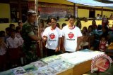 Komandan Batalyon 123 Rajawali memberi kaos Aku Cinta Indonesia ke penduduk perbatasan