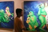 Jakarta (Antara Bali) - Pengunjung mengamati lukisan kodok pada pembukaan pameran lukisan Budi Karmanto "Catatan Harian Biru" di Galeri Citra 3, TIM, Jakarta, Selasa (2/4) malam. Pameran tersebut akan berlangsung hingga 15 April 2013. FOTO ANTARA/Dodo Karundeng/nym/2013.