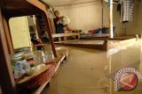 Lamongan (Antara Bali) - Sejumlah warga beraktifitas saat banjir menggenangi Desa Truni, Lamongan, Jawa Timur, Rabu (10/4). Sebanyak 255 rumah terendam banjir dengan ketinggian air sekitar 50 cm akibat luapan Bengawan Solo. FOTO ANTARA/Syaiful Arif/nym/2013.
