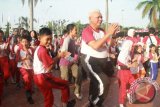 Gubernur Kaltim Dr H Awang Faroek Ishak melakukan senam bersama anak peserta Jalan Sehat Penyandang Autis "Walk for Autism Hand in Hand", di halaman Kantor Gubernur, Samarinda, Sabtu (6/4).  Menurut Gubernur, anak-anak autis tidak berbeda dengan anak-anak normal lainnya, bahkan anak-anak autis ada pula yang memiliki kecerdasan tinggi. (Yuliawan/Humas Pemprov Kaltim)