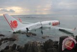 Denpasar (Antara Bali) - Pesawat Lion Air tergelincir ke laut setelah berusaha mendarat di Bandara Ngurah Rai Denpasar, Bali, Sabtu (13/4). Pesawat Lion Air dengan nomor penerbangan JT-960 rute Bandung-Denpasar tergelincir di Bandara Ngurah Rai saat mendarat sehingga menyebabkan ratusan penumpang cedera. FOTO ANTARA/Hand Out Polda Bali/nym/2013.