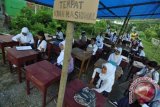 Donggala (Antara Bali) - Sejumlah pelajar SMP Negeri 1 Tanantovea menunggu pelaksanaan Ujian Nasional (UN) pada tenda darurat yang dibangun oleh warga di depan sekolah mereka di Desa Nupabomba, Kabupaten Donggala, Sulawesi Tengah, Senin (22/4). Ujian Nasional di SMP Negeri 1 Tanantovea yang diikuti 26 pelajar, mengalami kendala dan sempat tertunda hingga dua jam dari jadwal yang ditentukan akibat sekolah tersebut disegel oleh warga yang mengaku sebagai pemilik lahan.FOTO ANTARA/Mohamad Hamzah/nym/2013.