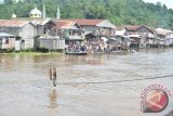 Samarinda (ANTARA Kaltim) - SejUmlah warga menyaksikan jangkar yang ditarik menggunakan 'craine' dari atas ponton yang digunakan tim SAR untuk mengevakuasi bangkai kapal KM Karya Indah dari atas sebuah ponton di depan Dermaga Loa Janan, Kelurahan Harapan Baru, Kecamatan Loa Janan, Samarinda, Sabtu (20/4). KM Karya Indah, tenggelam sekitar 50 meter dari Dermaga Loa Janan, yang diperkirakan mengangkut 68 pegawai borongan PT Kalimur, sebuah perusahaan pengolahan kayu pada Rabu (17/4) sekitar pukul 18.15 Wita menyebabkan 19 orang tewas, empat masih dinyatakan hilang dan 40 penumpang berhasil selamat. (Amirullah/ANTARA) 