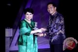 Menteri Perdagangan Gita Wirjawan memberikan penghargaan SCTV Award 2013 Lifetime Achievement kepada penyanyi senior Titiek Puspa di malam anugerah SCTV Award 2013 di Hall D JIEXPO Kemayoran, Jakarta, Senin, (29/4). Titiek Puspa mendapat penghargaan SCTV Award 2013 Lifetime Achievement untuk dedikasinya dalam industri musik Indonesia. FOTO ANTARA/Muhammad Adimaja/ss/pd/13