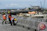 Denpasar (Antara Bali) - Tiga pekerja menyelesaikan pekerjaan tahap akhir jalan tol penghubung Bandara Ngurah Rai-Nusa Dua di Denpasar, Jumat (12/4). Jalan bebas hambatan sepanjang 12,1 Km di atas laut itu ditargetkan dapat diuji kelaikan pada Mei 2013 sehingga menjelang KTT APEC jalan tersebut sudah dapat beroperasi untuk memperlancar kegiatan itu. FOTO ANTARA/Nyoman Budhiana/nym/2013.