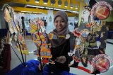 Pengunjung memainkan jenis wayang kulit Cina yang dipamerkan dalam pagelaran Wayang Goes To Campus di Balairung UI, Depok, Jawa Barat, Kamis (4/4). Pagelaran Wayang Goes To Campus tersebut menampilkan pameran berbagai jenis wayang berikut pementasannya yang berlangsung 4 - 5 April 2013. FOTO ANTARA/Indrianto Eko Suwarso/adt/2013.