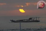 Sanur (Antara Bali) - Sebuah perahu melintas saat terjadinya gerhana matahari cincin di Pantai Sanur, Bali, Jumat (10/5). Gerhana matahari cincin yang terjadi mulai pukul 5.39 Wita hingga 7.36 Wita itu dapat dilihat dari Samudera Pasifik namun di kawasan timur Indonesia terlihat berupa gerhana matahari sebagian. FOTO ANTARA/Nyoman Budhiana/nym/2013.