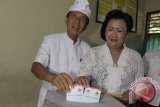 Calon Gubernur nomor urut 2, Made Mangku Pastika bersama Nyonya Ayu Pastika memasukkan surat suara saat menggunakan hak pilihnya di Denpasar, Rabu (15/5). Foto Antara/Nyoman Budhiana/nym/2013.