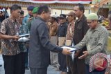 Bupati Nunukan Drs Basri menyerahkan sertifikat penghargaan kepada warga yang menghibahkan lahannya untuk kepentingan umum di Kecamatan Sebatik Barat, Nunukan, Kalimantan Utara, Jumat (10/5). (M Rusman/ANTARA Kaltim)


