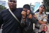Petugas Kepolisian mengamankan seorang pria yang diduga provokator kericuhan saat pemeriksaan Ketua Majelis Syuro PKS Hilmi Aminuddin di Komisi Pemberantasan Korupsi di Jakarta, Selasa (14/5). Pemeriksaan Hilmi sebagai saksi terkait kasus tindak pidana pencucian uang dalam kasus dugaan penerimaan suap penetapan kuota impor daging sapi, berakhir ricuh karena puluhan yang diduga pengawalnya terus menghalang-halangi saat diliput wartawan. ANTARA FOTO/Wahyu Putro A/nym/2013.