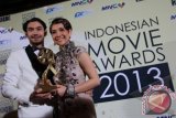 Pemeran Habibie & Ainun, Aktor Reza Rahardian (kiri), aktris Bunga Citra Lestari (kanan) menerima piala layar emas pada malam puncak Indonesian Movie Award 2013 di, Jakarta, Senin, (27/5). Habibie & Ainun terpilih sebagai film terfavorit Indonesian Movie Award 2013 pilihan permirsa dan polling sms sebagai film yang mendapat jumlah penonton terbanyak. ANTARA FOTO/Teresia May
