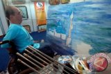 Seniman, Benjamin Tan (54) asal Singapura yang tergabung dalam AMFPA (Association of Mouth and Foot Painting Artist) menyelesaikan lukisan dengan menggunakan mulut di pasar seni lukis Indonesia (PSLI) 2013 di JX Internasional Surabaya, Jatim, Jumat (3/5). Ajang unjuk seni para seniman lukis diikuti sekitar 300 pelukis berlangsung 3-12 Mei 2013. FOTO ANTARA/M Risyal Hidayat/ss/mes/13.