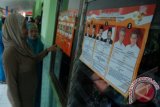 Sejumlah warga melihat profil kandidat Cagub dan Cabup saat Pilgub Jateng dan Pilbub Kudus di Undaan, Kudus, Jateng, Minggu (26/5). Menurut data KPU Jateng, sebanyak 27.385.985 warga tercatat menjadi pemilih tetap gubernur periode 2013-2018 yang berlangsung secara serentak hari ini. FOTO ANTARA/ Andreas Fitri Atmoko/nym/2013.