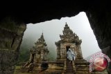 Wisatawan mengenakan jas hujan saat turun di komplek Candi Gedong Songo, Bandungan, Kabupaten Semarang, Jawa Tengah, Senin (17/6). Komplek Candi Hindu tersebut merupakan obyek wisata selain dilengkapi dengan pemandian air panas dari mata air yang mengandung belerang, juga area perkemahan, dan tempat wisata berkuda. ANTARA FOTO/Herka Yanis Pangaribowo/nym/2013.