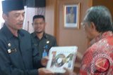 Menteri Riset dan teknologi (Menristek) Gusti Muhammad Hatta memberikan cenderamata kepada Wakil Bupati Penajam Paser Utara (PPU) Mustaqim MZ dalam kunjungan kerjanya ke Kabupaten PPU, Kaltim, Senin (10/6). (Bagus Purwa/ANTARA Kaltim)