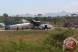Petugas berada di sisi Pesawat Merpati Nusantara Airlines (MNA) yang tergelincir dan patah di landasan pacu Bandara El Tari Kupang, NTT, Senin (10/6). Pesawat jenis M60 dengan nomor penerbangan MZ 5617 itu terbang dari Ngada, Flores, membawa 46 penumpang dan empat kru. Tidak ada korban jiwa dalam insiden itu, tetapi sedikitnya 25 orang terluka. ANTARA FOTO/Bernadus Tokan/nym/2013.