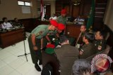 Tiga dari 12 anggota Kopassus terdakwa penyerang tahanan Lapas 2B Cebongan berkonsultasi dengan penasehat hukum mereka ketika menjalani sidang militer di Pengadilan Militer II-11 Yogyakarta, Bantul, Yogyakarta, Kamis (20/6). Sebanyak 12 prajurit Kopassus Grup II Kandang Menjangan Kartosura menjalani sidang perdana terkait penyerangan yang menewaskan 4 tahanan di Lapas 2B Cebongan. ANTARA FOTO/Noveradika/nym/2013.