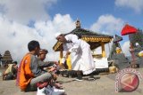 Seorang tetua agama memberikan air suci pada sejumlah warga suku Tengger saat berdoa sebagai rangkaian persiapan upacara Yadnya Kasada di Pura Luhur Poten di bawah kawah Gunung Bromo, Probolinggo, Jawa Timur, Selasa (23/7). Sembahyang dalam rangkaian persiapan upacara Kasodo yang merupakan ungkapan rasa syukur kepada Tuhan atas hasil panen yang melimpah tersebut diadakan setiap tanggal 14 penanggalan bulan Jawa. ANTARA FOTO/Ari Bowo Sucipto/nym/2013.