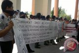 Pengunjuk rasa yang merupakan pegawai negeri sipil (PNS) dan tenaga honorer di lingkungan Pemkab PPU kembali melakukan unjuk rasa di depan Kantor Bupati PPU dengan membentangkan spanduk menolak mutasi, Kamis (4/7). (Bagus Purwa/ANTARA Kaltim)