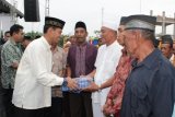 Beri Bingkisan: Bupati Simalungun JR Saragih (kiri) menyerahkan secara simbolis bingkisan kepada beberapa orang nazir masjid pada acara buka puasa bersama di  Kecamatan Perdagangan, Kamis (18/7). Pemberian bingkisan tersebut merupakan rangkaian dari kegiatan Safari Ramadhan pejabat Muspida Kabupaten Simalungun.  (Foto Antarasumut/Waristo)