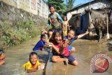 Sejumlah anak bermain lumpur sisa luapan air kali Bekasi di kampung Margajaya, Bekasi Timur, Bekasi, Jumat (12/7). Badan Meteorologi, Klimatologi, dan Geofisika (BMKG) memperkirakan hujan masih akan turun di sebagian wilayah Indonesia yang berada di selatan ekuator sampai akhir Agustus 2013, hujan ekstrim di musim kemarau ini disebabkan gangguan pola angin di selatan Pulau Jawa. ANTARA FOTO/Paramayuda