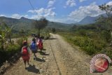 Siswa SD berjalan menuju sekolahnya yang berjarak sekitar 10-15 kilometer di Desa Looluna, Belu, NTT, Kamis (4/7). Pendidikan Dasar di perbatasan Indonesia-Timor Leste tersebut terkendala jarak dan minimnya fasilitas pendidikan, termasuk guru dan buku pelajaran sehingga masyarakat berharap pemerintah pusat dapat memberikan bantuan itu. ANTARA FOTO/Yudhi Mahatma/Koz/Spt/13