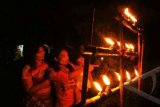 Warga melihat obor bambu yang baru dinyalakan di rumahnya, di Kayutanam, Padangpariaman, Sumbar, Senin (5/8). Tradisi membakar lilin dan obor dilakukan warga Padangpariaman di masing-masing rumah dalam rangka menyambut malam 27 ramadhan. ANTARA FOTO/Iggoy el Fitra/ss/ama/13