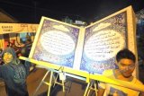 Peserta membawa miniatur Al Quran Raksasa dalam pawai malam takbiran di Klaseman, Salatiga, Jateng, Rabu (7/8). Pawai malam takbiran yang diikuti ratusan peserta yang terdiri dari orang tua hingga anak-anak tersebut untuk menyambut Idul Fitri 1434 H.ANTARA FOTO/Wahyu Putro A/hp/13