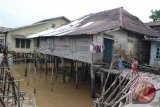 Anak-anak tengah bermain di halaman rumah yang dibangun di bantaran Sungai Kapuas. (Teguh Imam Wibowo)