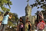 Sejumlah wisatawan berfoto di depan potongan patung Wisnu yaitu bagian dari patung Garuda Wisnu Kencana (GWK), Badung, Bali, Kamis (22/8). Proyek patung GWK setinggi 126 meter tersebut akan dilanjutkan kembali pembangunannya sesuai rancangan aslinya setelah sempat terhenti selama 16 tahun, sehingga ditargetkan menjadi kawasan wisata budaya berskala internasional. ANTARA FOTO/Nyoman Budhiana/nym/2013.