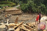 Dua orang anak menatap jembatan yang putus di kawasan Amahusu, Sirimau, Ambon, Maluku, Jumat (2/8). Sejumlah akses jalan di Kota Ambon masih terputus akibat longsor saat banjir bandang yang menyebabkan 1.805 kepala keluarga di daerah tersebut mengungsi ke sejumlah lokasi penampungan. ANTARA FOTO/Embong Salampessy/nym/2013.