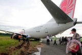 Komisi Nasional Keselamatan Transportasi (KNKT) memeriksa kondisi pesawat Lion Air di bandara Djalaludin, Gorontalo, Rabu (7/8). Roda pendaratan belakang sebelah kiri pesawat menabrak seekor sapi sehingga pesawat keluar landasan, Selasa (6/8) malam. FOTO ANTARA/Adiwinata Solihin/pd/13