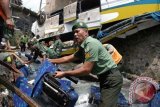 Sejumlah petugas mengevakuasi properti bus Giri Indah yang mengalami kecelakaan di Desa Tugu, Cisarua, Bogor, Jabar, Rabu (21/8). Kecelakaan bus yang membawa rombongan jemaat Gereja Bethel Indonesia Rahmat Emmanuel Ministry (GBI REM) Kelapa Gading itu menyebabkan 18 penumpang tewas, 32 orang luka berat, 10 orang luka ringan dan sebuah mobil barang rusak berat. ANTARA FOTO/Jafkhairi/nym/2013.