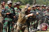 Seorang prajurit US MARSOC memberikan contoh posisi menembak dengan menggunakan senjata MP5 kepada sejumlah prajurit Korps Marinir TNI AL di lapangan tembak Pusat Latihan Tempur Korps Marinir Baluran, Karangtekok, Situbondo, Jatim, Rabu, (20/8). Menembak dengan senjata MP5 merupakan salah satu materi yang dilatihkan dalam Latihan Bersama Lantern Iron 13 ï¿½ 1 antara prajurit Marinir Indonesia dan Marinir Amerika yang digelar hingga 6 September 2013. ANTARA FOTO/Kuwadi/ss/Spt/13