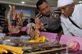 Kabid Humas Polda Bali, Kombes Pol. Hariadi (kiri) bersama tokoh Agama Hindu saat mengidentifikasi benda sakral dalam gelar kasus pencurian Pratima di Polda Bali, Rabu (28/8). Polisi berhasil menahan 4 pelaku pencurian dan menyita puluhan benda-benda sakral dari sekitar 39 Pura di 5 Kabupaten di Bali. ANTARAFOTO/Nyoman Budhiana/nym/2013.