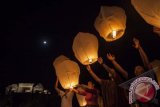 Wisatawan menerbangkan lampion Laksita Teja Kirana dalam acara Purnama Hamengku Boko di kompleks Situs Ratu Boko, Prambanan, Sleman, Kamis (22/8). Pertunjukkan yang digelar rutin setiap bulan purnama tersebut bertemakan Sabda Pancering Nagari untuk memperkokoh rasa cinta terhadap seni dan budaya yang diharapkan mampu mengembalikan kejayaan nusantara. ANTARA FOTO/Sigid Kurniawan/nym/2013.