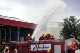 Sejumlah petugas memadamkan api saat simulasi keadaan darurat kebakaran tangki suplai bahan bakar di Terminal Bahan Bakar Minyak (TBBM) Pesanggaran, Denpasar, Bali, Jumat (30/8). Latihan penanganan bencana tersebut digelar untuk kesiapsiagaan bagi petugas PT. Pertamina dalam melindungi obyek vital nasional sekaligus kesiapan menjelang KTT APEC 2013. ANTARA FOTO/Nyoman Budhiana/nym/2013.