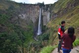 Seorang pengunjung memotret temannya dengan latar belakang Air Terjun Sipiso-piso di Merek, Kabupaten Karo, Sumut, Sabtu (17/8). Air terjun Sipiso-Piso yang terletak bersebrangan dengan Danau Toba tersebut ramai dikunjungi wisatawan saat perayaan Hari Kemerdekaan Indonesia. (Foto Antarasumut/Fai)<br />
<br />
 