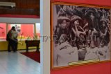 : Pengunjung memperhatikan salah satu koleksi Museum Negeri Sumatera Utara pada Pameran Potret Kehidupan Masyarakat Sumatera Utara di Masa Perjuangan di Medan, Sumut, Jumat (23/8). Pameran yang menampilkan sejumlah foto masa perjuangan tersebut bertujuan untuk untuk memberikan informasi tentang benda-benda/potret yang mempunyai nilai sejarah perjuangan masa lampau di Sumatera Utara akan berlangsung hingga 20 September 2013. (Foto antarasumut/M Syafii)