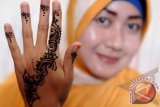 Seorang perempuan menunjukkan tangannya yang baru saja dilukis dengan seni lukis tangan, di Palu, Sulawesi Tengah, Sabtu (31/8). Seni lukis tangan yang biasa diperuntukkan bagi calon mempelai wanita pada sehari menjelang pernikahan adat kini telah menjadi gaya hidup sebagian perempuan. ANTARAFOTO/Basri Marzuki