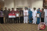 Kepala BPMPD Kaltim Moh Jauhar Efendi (batik coklat) foto bareng dengan Lurah Manggar Baru Balikpapan Timur Muhammad Idris (membawa piala sebagai Juara III Lurah Terbaik Tingkat Nasional), Camat Balikpapan Timur, Kabid ketahanan Sosial dan Budaya Masyarakat BPMPD Kaltim (kedua dari kiri), usai penyerahan penghargaan dari Mendagri Gamawan Fauzi di Jakarta, Jumat (16/8). (M Ghofar/ANTARA)