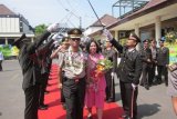 Kediri (Antara Jatim) - Kepala Polres Kediri Kota lama AKBP Ratno Kuncoro dengan istri diapit petugas dalam tradisi pedang pora saat serah terima jabatan dengan Kapolres baru AKBP Budhi Herdi Susianto di markas polres setempat, Senin (16/9). Kapolres baru berjanji akan meneruskan program serta termasuk upaya penanganan sejumlah kasus dugaan korupsi di Kediri. FOTO Asmaul Chusna/13/Chan.