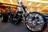 Seorang pengunjung melihat motor modifikasi yang terbuat dari tembaga dan kuningan yang dipajang diajang Art of the Chopper Exibation di Mall Living World, Serpong, Tangerang Selatan, Banten, Rabu (11/9). Pameran modifikasi motor besar yang terbuat dari tembaga dan kuningan ini merupakan pameran pertama yang diadakan di Indonesia. ANTARA FOTO/Muhammad Iqbal/ss/ama/13