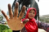 Seorang karyawan menunjukkan jari tangannya usai menjalani pengambilan sidik jari oleh pihak kepolisian di Museum Nasional, Jakarta, Jumat (13/9). Pihak keploisian hingga saat ini telah memeriksa 28 saksi dari pihak internal Museum Nasional terkait hilangnya empat koleksi artefak emas peninggalan Majapahit dan Mataram kuno yakni lempengan Bulan Sabit Beraksara, lempengan Halihara, lempengan Naga dan Wadah Bertutup (Cepuk). ANTARA FOTO/Dhoni Setiawan/Koz/pd/13.