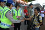 Pamekasan (Antara Jatim)-Seorang Polisi Wanita (Polwan) memberikan bunga kepada wartawan (kanan) sesaat sebelum pertandingan kompetisi  Indonesia Super League (ISL) antara Persepam Madura United (P-MU) melawan Persiwa Wamena, di Stadion Gelora Bangkalan (SGB) Bangkalan, Minggu  (1/9). Moment tersebut bertepatan dengan HUT ke-65 Polwan yang jatuh pada tanggal 1 September 2013. FOTO ANTARA/ Saiful Bahri/13/Oka.