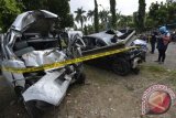 Jurnalis memotret mobil sedan Mitsubishi Lancer B 80 SAL (kanan) yang dikemudikan oleh putra bungsu musisi Ahmad Dani, Abdul Qodir Jaelani yang terlibat kecelakaan dengan Daihatsu Gran Max B 1349 TFN (kiri) di tol Jagorawi Km 8 yang terparkir di Satlantas Wilayah Jakarta Timur, Jakarta, Minggu (8/9). Kecelakaan yang melibatkan tiga mobil yakni Sedan Mitsubishi Lancer B 80 SAL, Granmax B 1349 TFN dan Avanza B 1882 UZJ itu terjadi Minggu (8/9) sekitar pukul 01.00 WIB mengakibatkan lima orang tewas dan sebelas orang luka-luka. ANTARA FOTO/Widodo S. Jusuf/nym/2013.